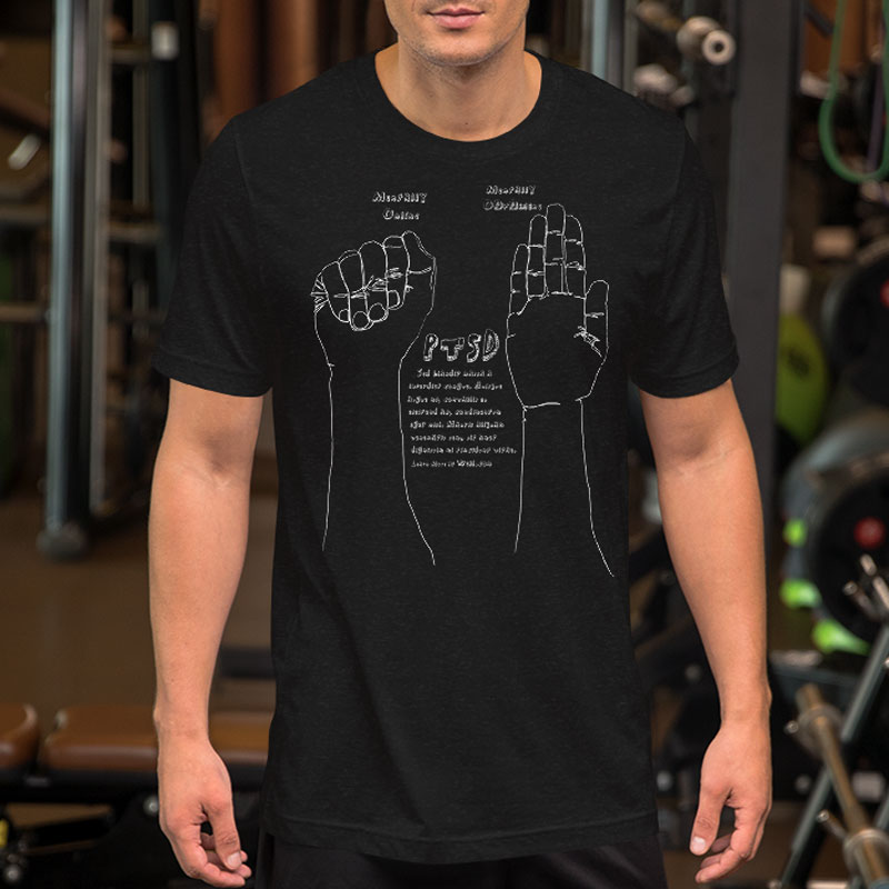 Man wearing a dark gray t shirt with white line drawn hands, one a fist the other open flat, with text about PTSD